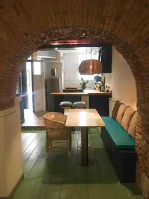 a living room with a table and a kitchen at Farnese Muse in Rome