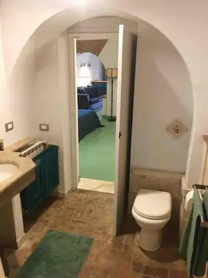 a bathroom with a toilet and a sink and a bedroom at Farnese Muse in Rome