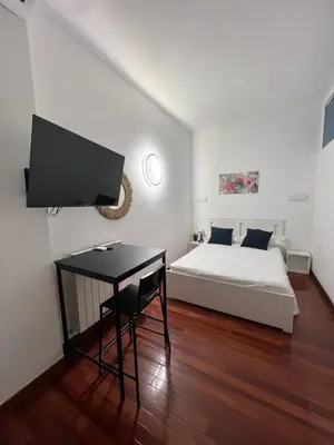 a bedroom with a bed and a desk with a television at Casa vacanza “Eden” in Rome