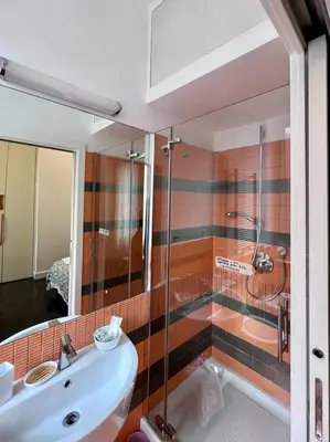 a bathroom with a glass shower and a sink at B&B Azuni Home in Rome