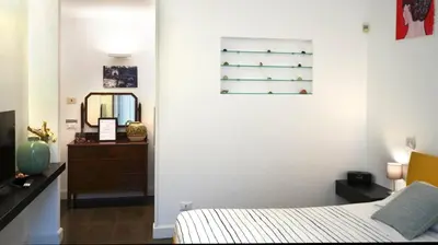 a bedroom with a bed and a dresser and a mirror at B&B Azuni Home in Rome