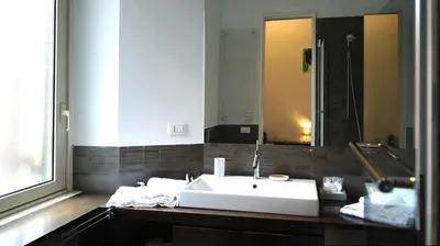 a bathroom with a white sink and a mirror at B&B Azuni Home in Rome