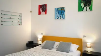 a bedroom with a bed with three paintings on the wall at B&B Azuni Home in Rome