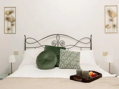 a bed with a green pillow and a basket of fruit at The Best Rent - Large apartment a few steps from the Trevi Fountain in Rome