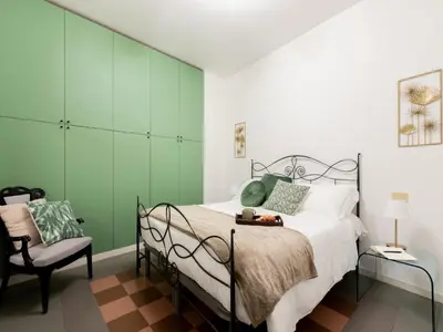 a bedroom with green walls and a bed and a chair at The Best Rent - Large apartment a few steps from the Trevi Fountain in Rome