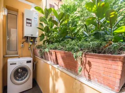 a washing machine sitting next to a window with plants at The Best Rent - Large apartment a few steps from the Trevi Fountain in Rome
