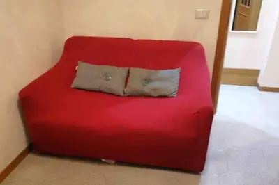 a red couch with a pillow on top of it at Domus romae esquilini in Rome