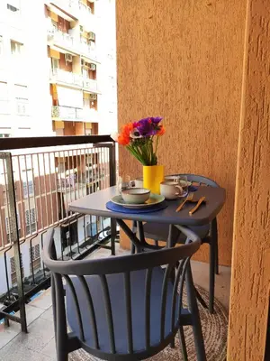 a table with a vase of flowers on a balcony at MT apartment in Rome