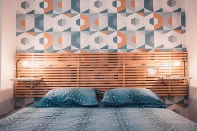 a bedroom with a bed with a tiled wall at MT apartment in Rome