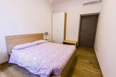 a bedroom with a bed with a purple comforter at Colossehome - Dream House around the corner from Colosseum in Rome