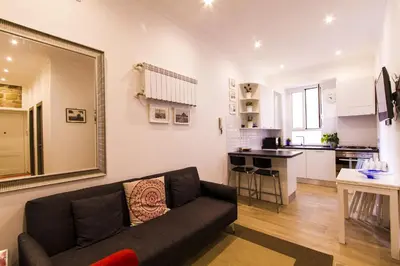 a living room with a couch and a kitchen at Colossehome - Dream House around the corner from Colosseum in Rome