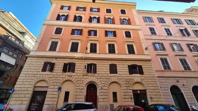a tall building with a clock tower on top of it at Colossehome - Dream House around the corner from Colosseum in Rome
