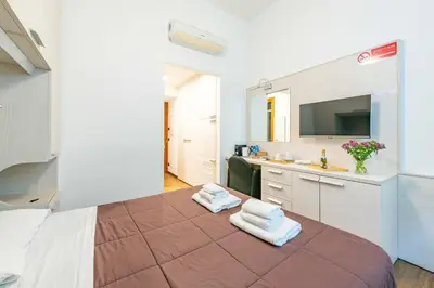 a room with a bed and a sink and a bathroom at ANDENIS TIBER HOUSE in Rome