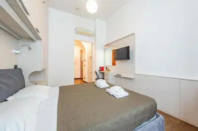 a bedroom with a bed and a flat screen tv at ANDENIS TIBER HOUSE in Rome