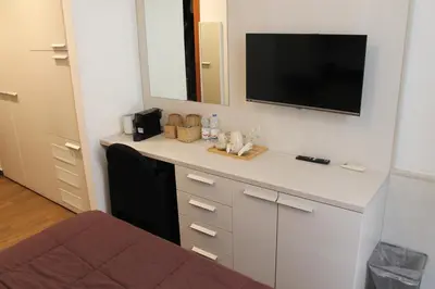 a room with a desk with a tv on the wall at ANDENIS TIBER HOUSE in Rome