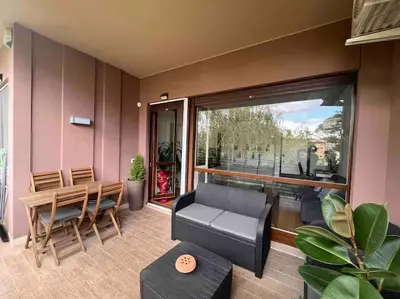 a living room with a table and chairs and a window at Moderno bilocale con terrazzo in Rome
