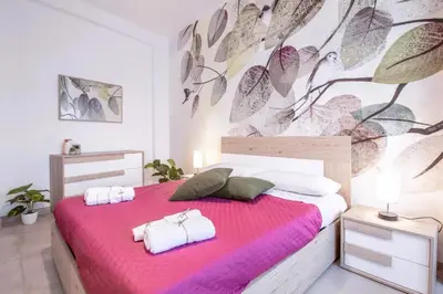 a bedroom with a pink bed with towels on it at Green House Exclusive Suite near Metro A in Rome