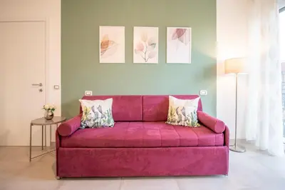 a bedroom with a large pink bed with two pillows at Green House Exclusive Suite near Metro A in Rome