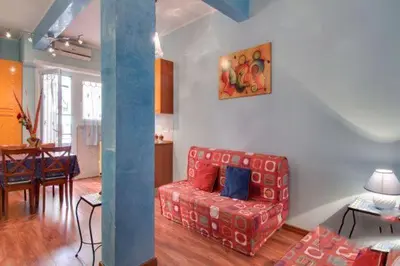 a living room with a red couch and a dining room at Olimpia Apartment in Rome