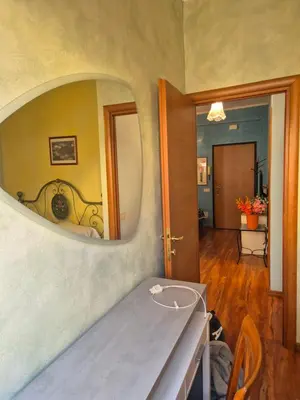 a room with a mirror on the wall with a table at Olimpia Apartment in Rome