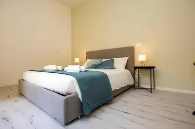 a bedroom with a large bed with two lamps on it at 1 Minute from San Pietro - Nicole House in Rome