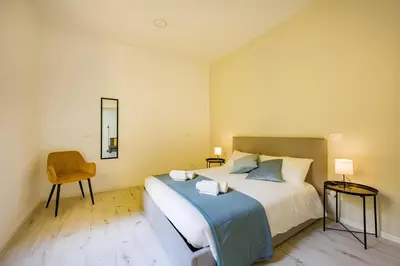 a bedroom with a large bed and a chair at 1 Minute from San Pietro - Nicole House in Rome