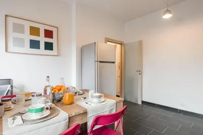 a kitchen with white cabinets and a table at Dalia's Place in Rome