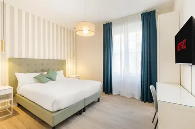 a bedroom with a white bed and a television at AlbaDea Apartment in Rome