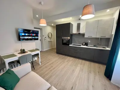 a kitchen and living room with a couch and a table at AlbaDea Apartment in Rome