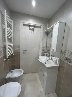 a white bathroom with a toilet and a sink at Claire House in Rome