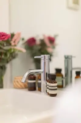 a bathroom sink with a bottle of soap next to a faucet at Pantheon Luxury House - ZEN 28 in Rome