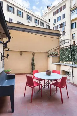 a patio with a table and chairs and a piano at Angelico Vatican Apartment by Oneup Hospitality in Rome