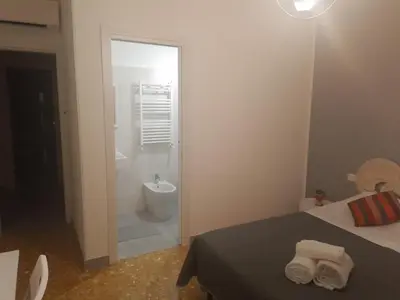 a bedroom with a bathroom with a toilet and a shower at Urban cosy rooms in Rome