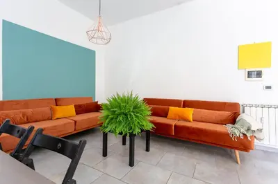 a living room with two orange couches and a plant at Maison Balduina in Rome
