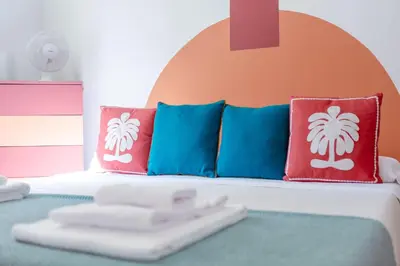 a bed with colorful pillows and a white remote control at Maison Balduina in Rome