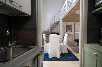 a kitchen with a table and chairs and a staircase at Casa Bartolomeo - Loft in Trastevere in Rome