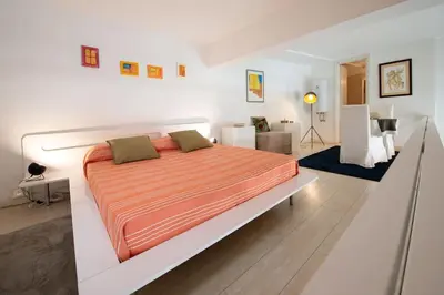 a bedroom with a large bed in a white room at Casa Bartolomeo - Loft in Trastevere in Rome