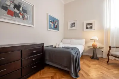 a bedroom with a bed and a dresser and a chair at Top View Luxury apartment Piazza del Popolo in Rome