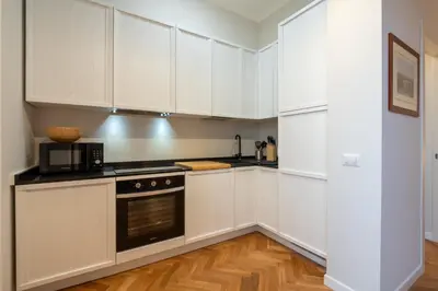 a kitchen with white cabinets and a stove top oven at Top View Luxury apartment Piazza del Popolo in Rome