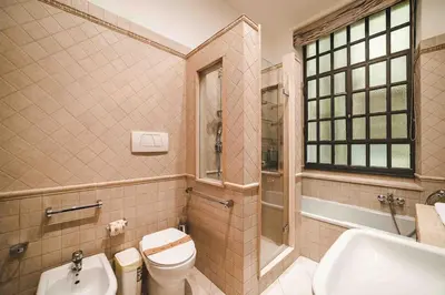 a bedroom with two beds and a chair at Domus trastevere 900 in Rome