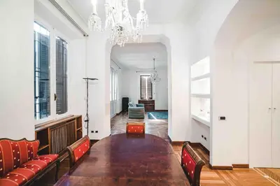 a dining room with a long table and a chandelier at Domus trastevere 900 in Rome