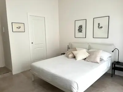 a bedroom with a white bed with four pictures on the wall at Paula Petra Vatican Apartments in Rome