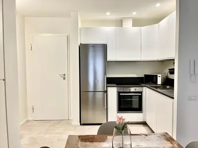 a kitchen with white cabinets and a stainless steel refrigerator at Paula Petra Vatican Apartments in Rome