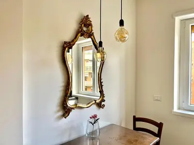 a dining room with a mirror and a table at Paula Petra Vatican Apartments in Rome