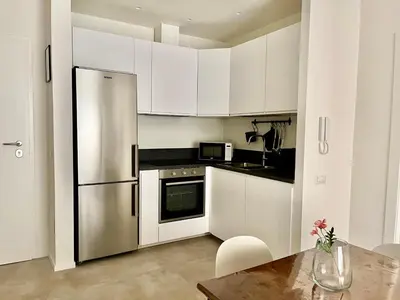a kitchen with white cabinets and a stainless steel refrigerator at Paula Petra Vatican Apartments in Rome