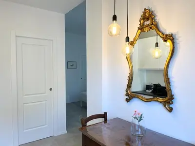 a dining room with a mirror and a table at Paula Petra Vatican Apartments in Rome