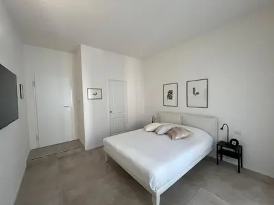 a white bedroom with a bed and a table at Paula Petra Vatican Apartments in Rome