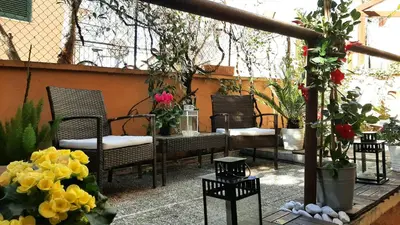 a patio with chairs and a table and flowers at Casa Federico - beauty apartment with wonderful terrace in Rome