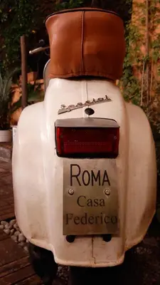 an old white scooter with a brown seat at Casa Federico - beauty apartment with wonderful terrace in Rome