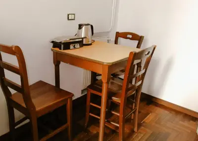 a wooden table with two chairs and a coffee maker on it at Minerva Rooms in Rome